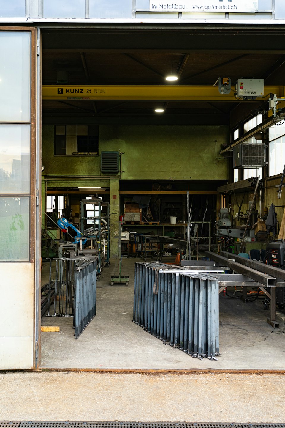 Metallwerkstatt-Innenraum mit Maschinen und Kran.